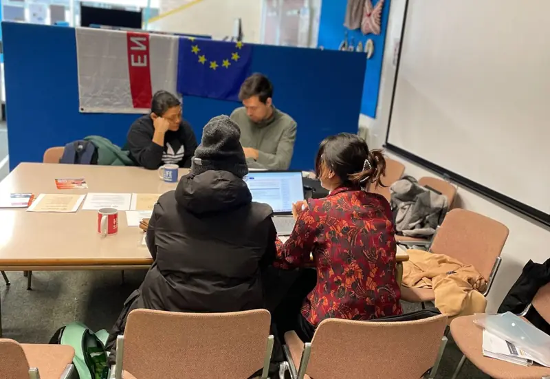 An adviser and a family member going through paperwork at a table