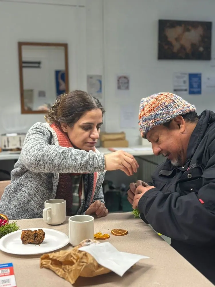 A volunteer serving food to a visitor at a Hope Beyond Borders session